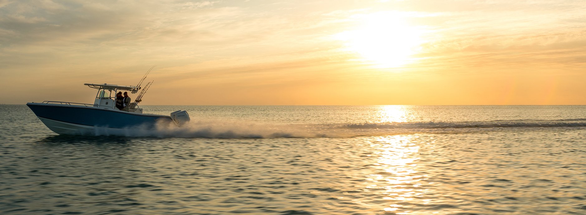 Sun setting on lake with boat on the water
